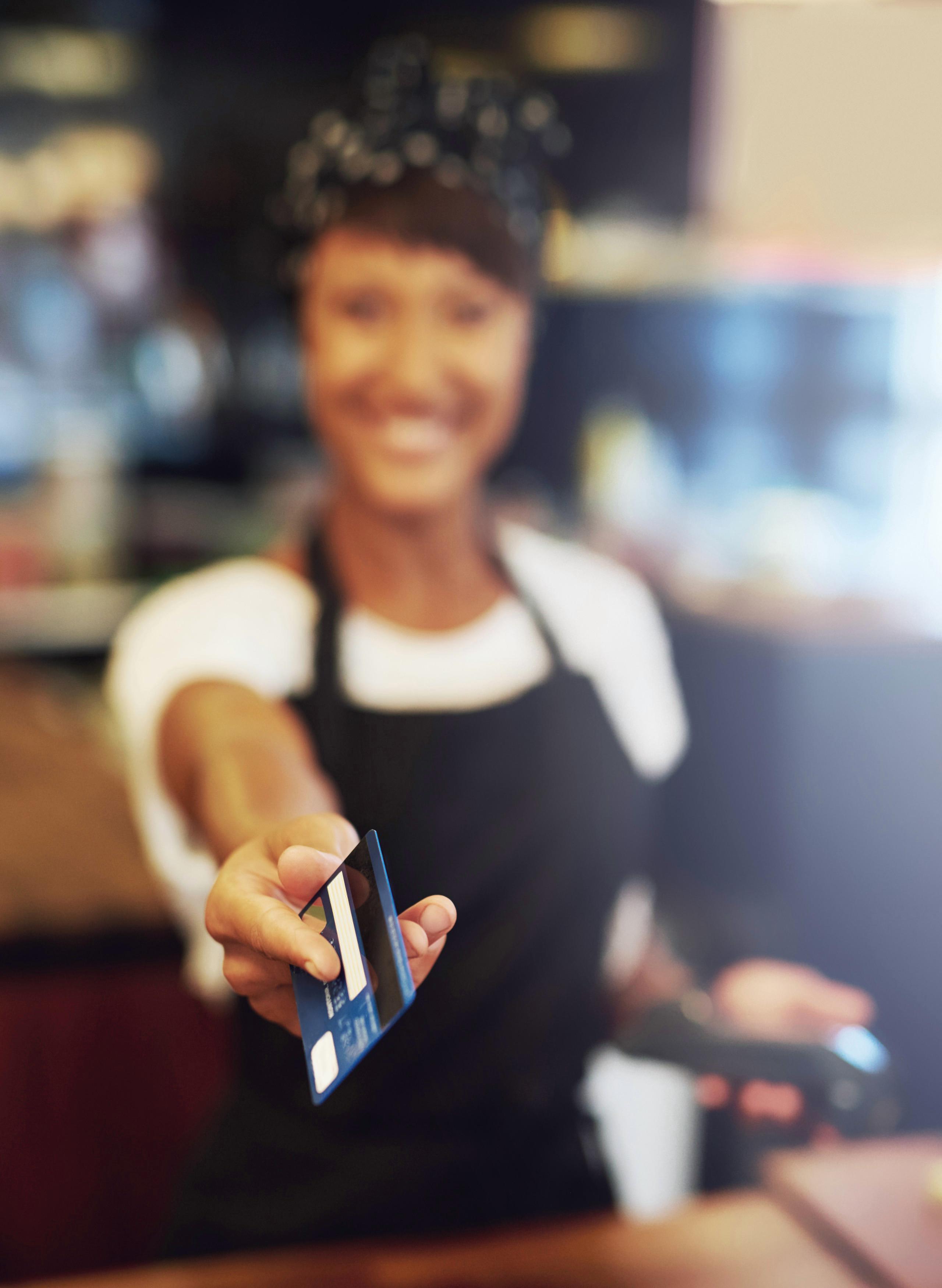 Small business owner returning a credit card back to the customer.